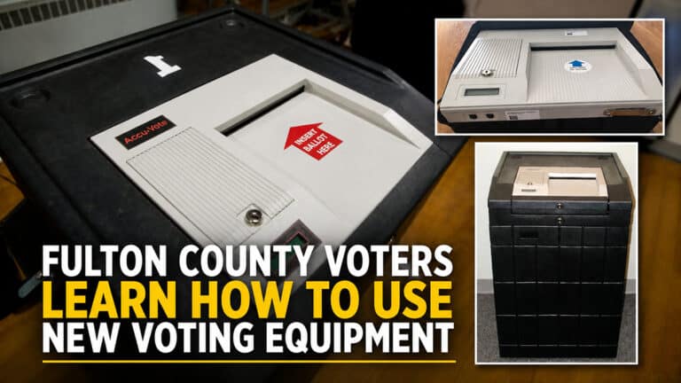 AccuVote ES-2000 voting machine and ballot box shown in a demonstration setup, illustrating new paper ballot voting equipment used in Fulton County elections